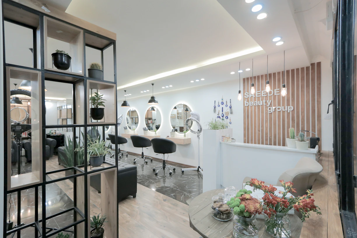 A serene beauty studio interior featuring soft cream and gold accents with a stylist gently working on afro hair.