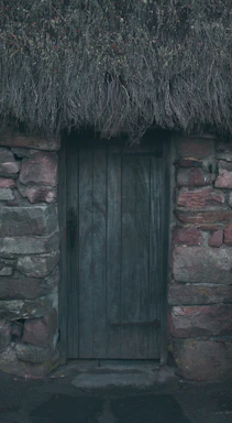 Cozy rustic wooden door of a countryside grill restaurant beside a scenic road.