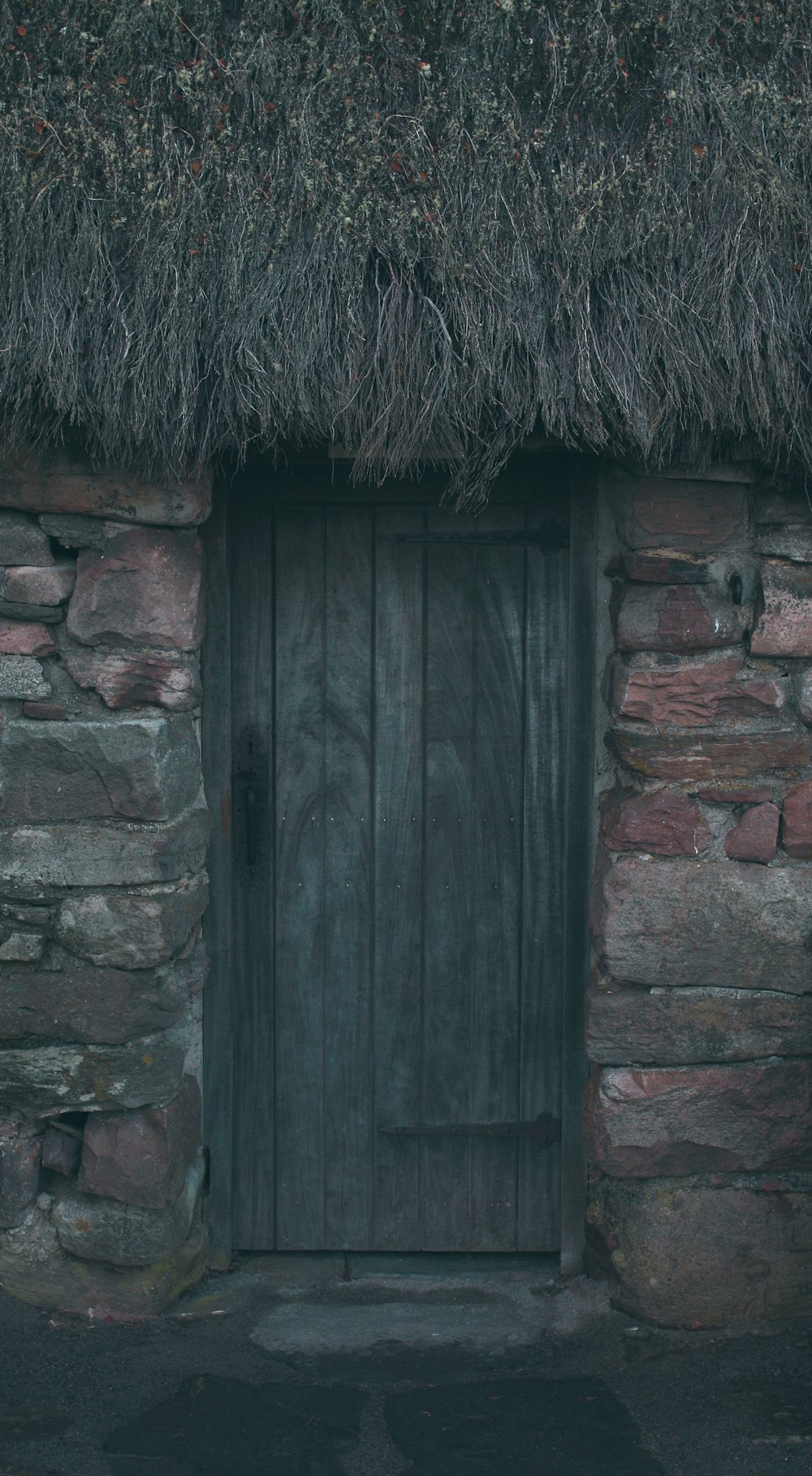 un edificio de piedra con techo de paja y una puerta de madera