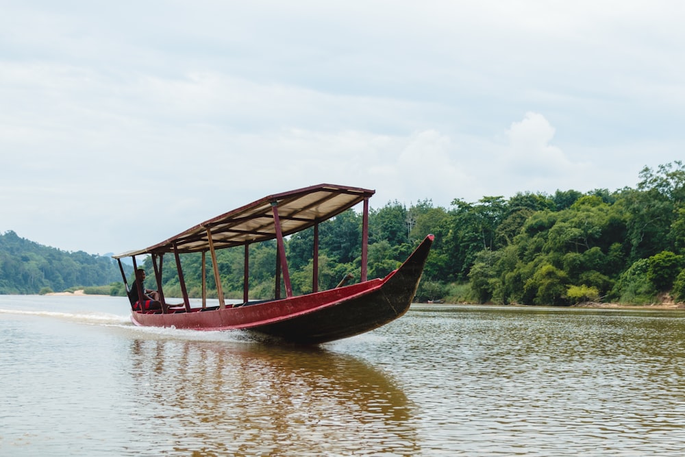 a long boat with a canopy on the water