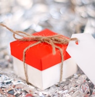 a red and white gift box with a white tag