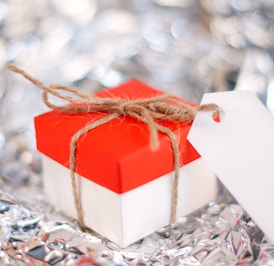 a red and white gift box with a white tag