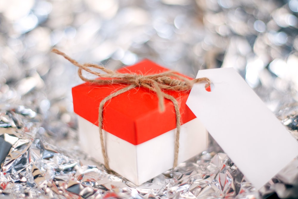 a red and white gift box with a white tag