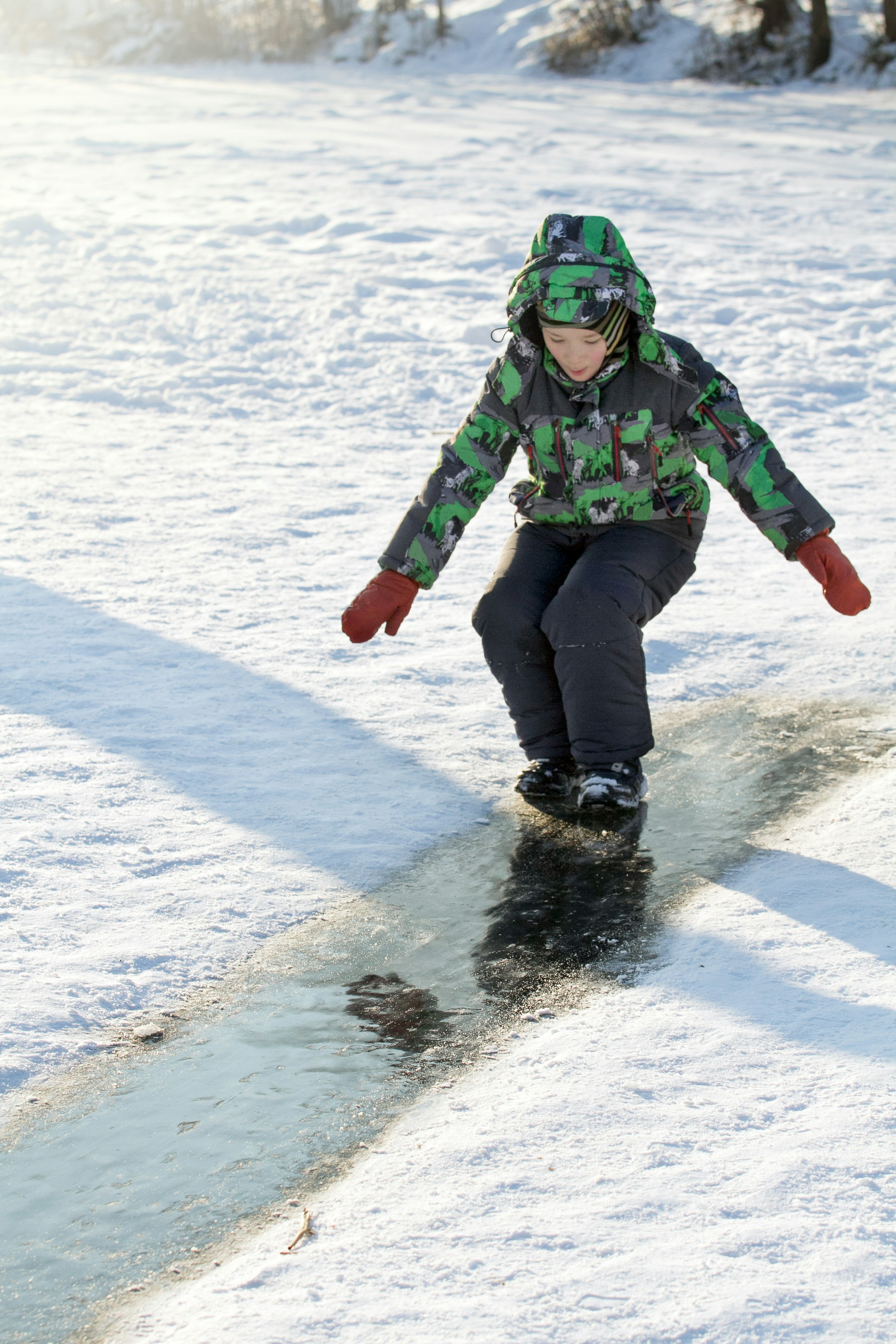 a person riding a snowboard down a snow covered slope