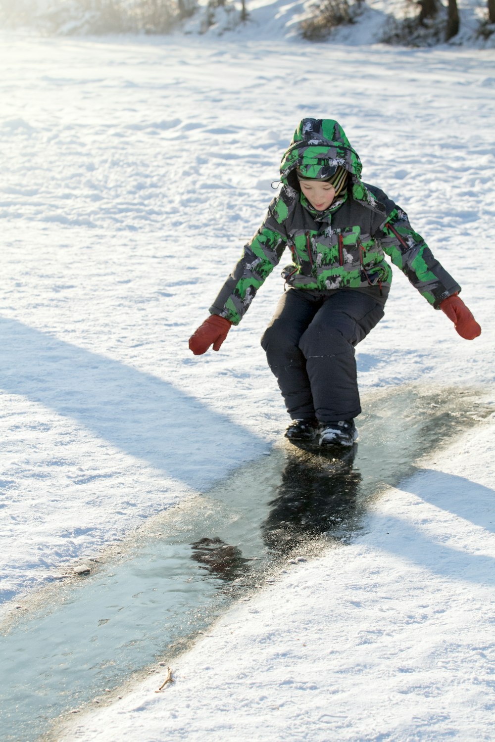 a person riding a snowboard down a snow covered slope