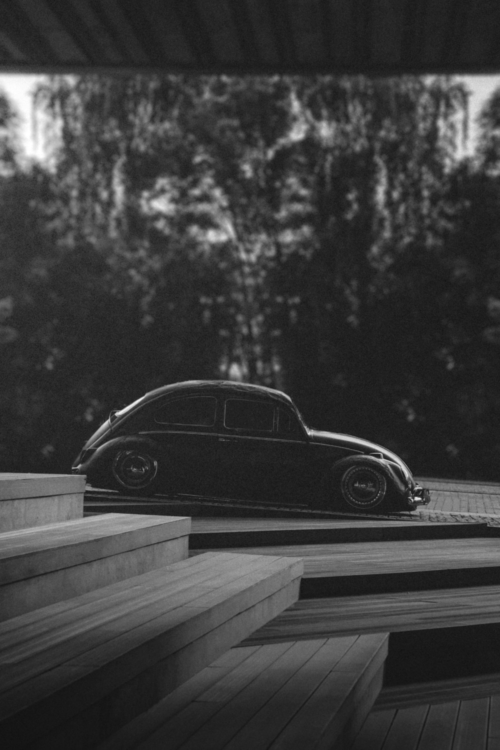 a black and white photo of a car parked on some steps