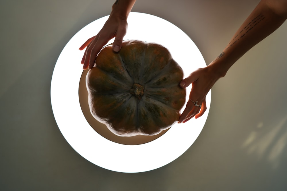 a person holding a pumpkin in their hands