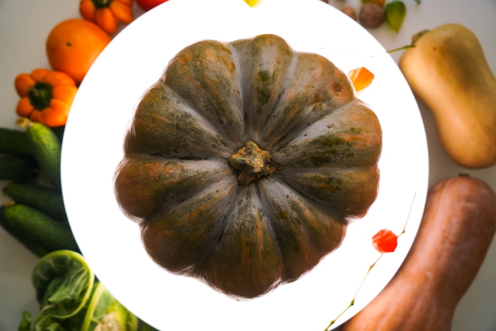 a white plate topped with a green pumpkin