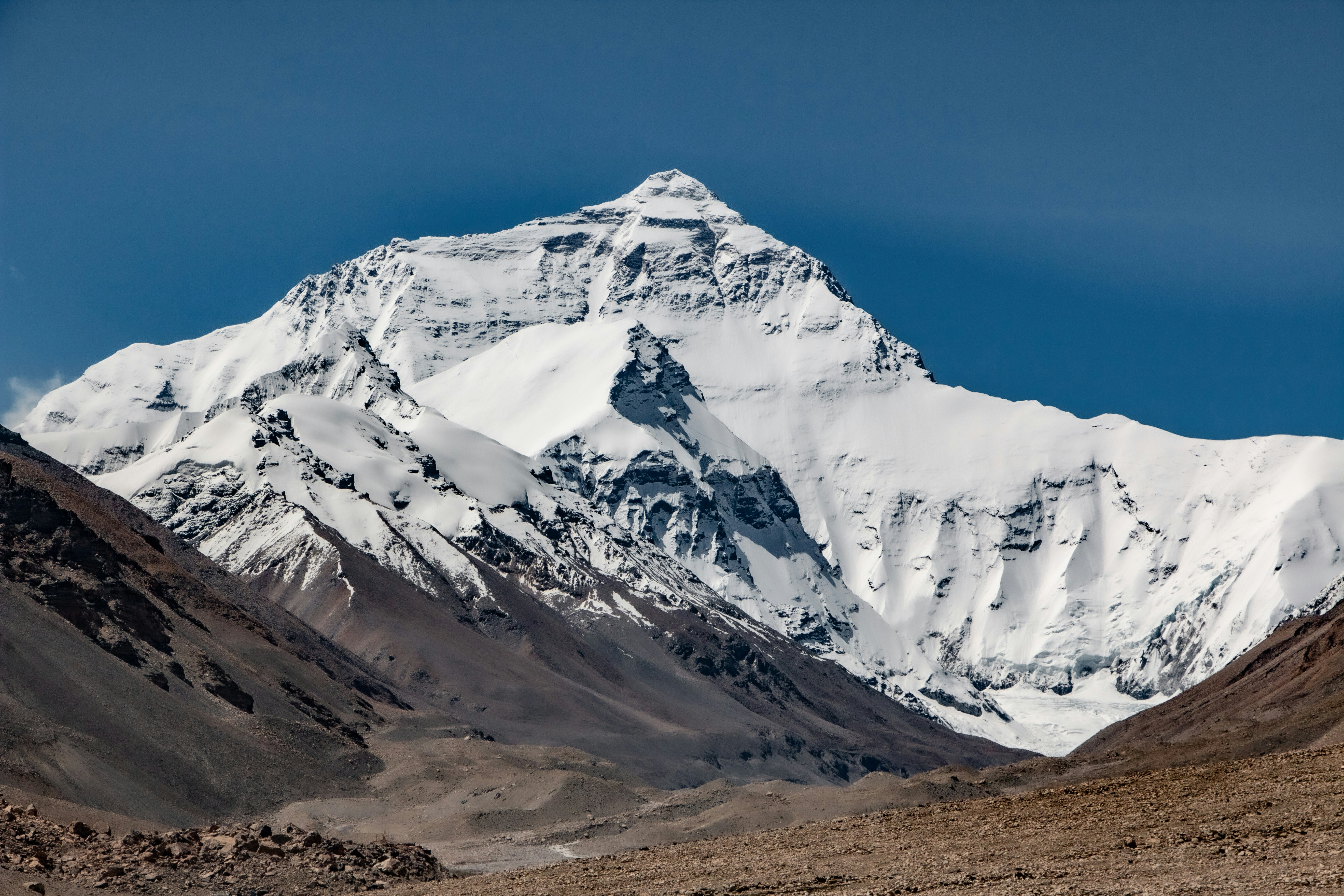 a snow covered mountain in the middle of a desert