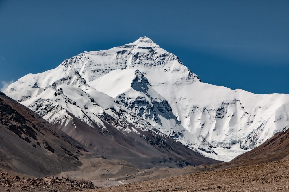 a snow covered mountain in the middle of a desert