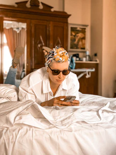 A user comfortably booking a shirt room service on a smartphone at home.