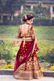 a woman in a red and gold lehenga