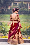 a woman in a red and gold lehenga