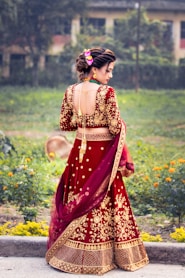 a woman in a red and gold lehenga