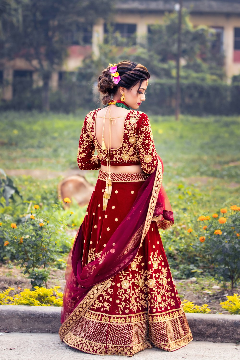 a woman in a red and gold lehenga