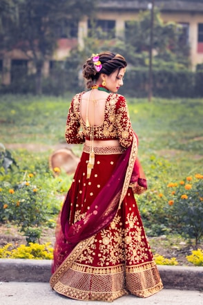 a woman in a red and gold lehenga