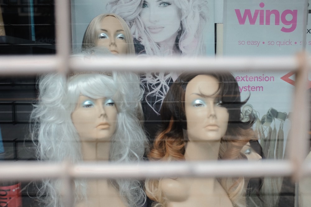 a window display of wigs in a store