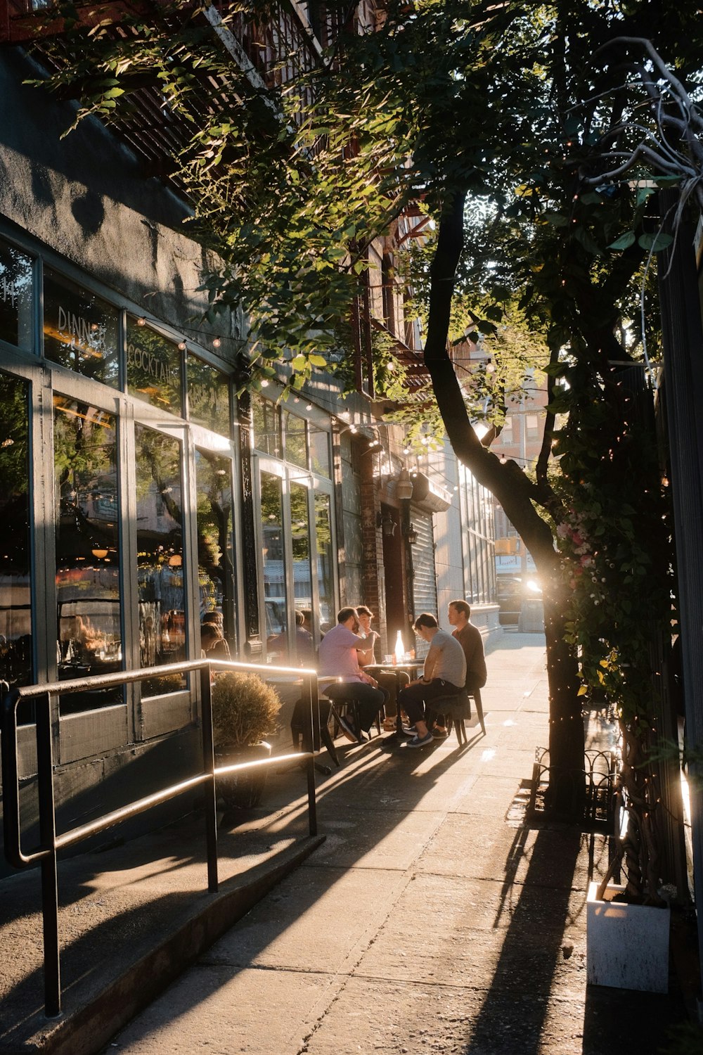 a group of people sitting at a table outside of a restaurant