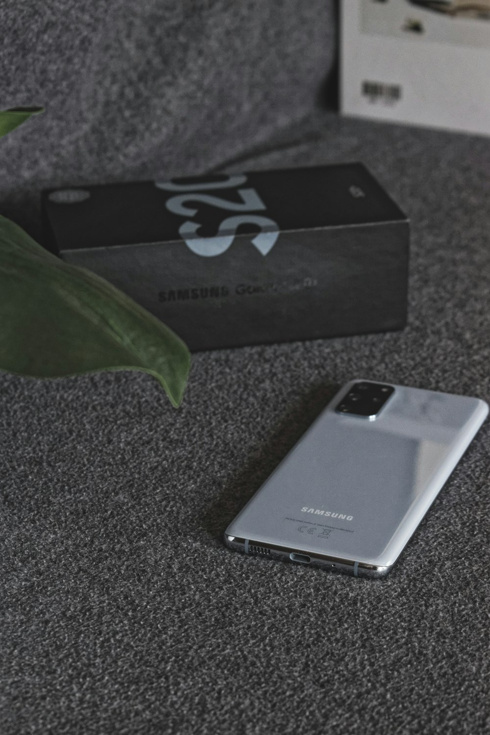 a cell phone sitting on top of a table next to a plant