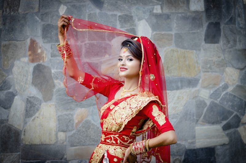 a woman in a red and gold bridal dress