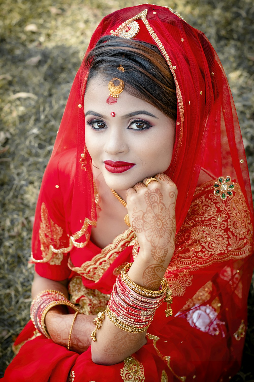 a woman in a red dress with a red veil on her head