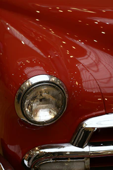 Close-up of a vintage car's polished chrome details reflecting soft light.