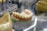 A close-up view of a dental model showing a partial set of artificial teeth and gums. The model is designed to demonstrate dental structure and is placed on a reflective surface. Nearby, there are additional dental models and tools, slightly out of focus.