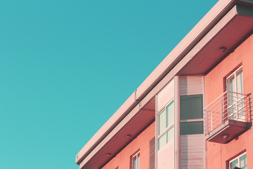 a pink building with a balcony and balconies