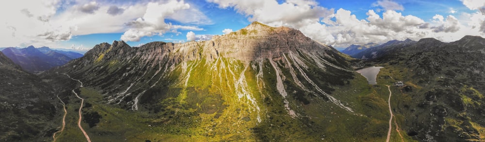 an aerial view of a mountain range with clouds in the sky