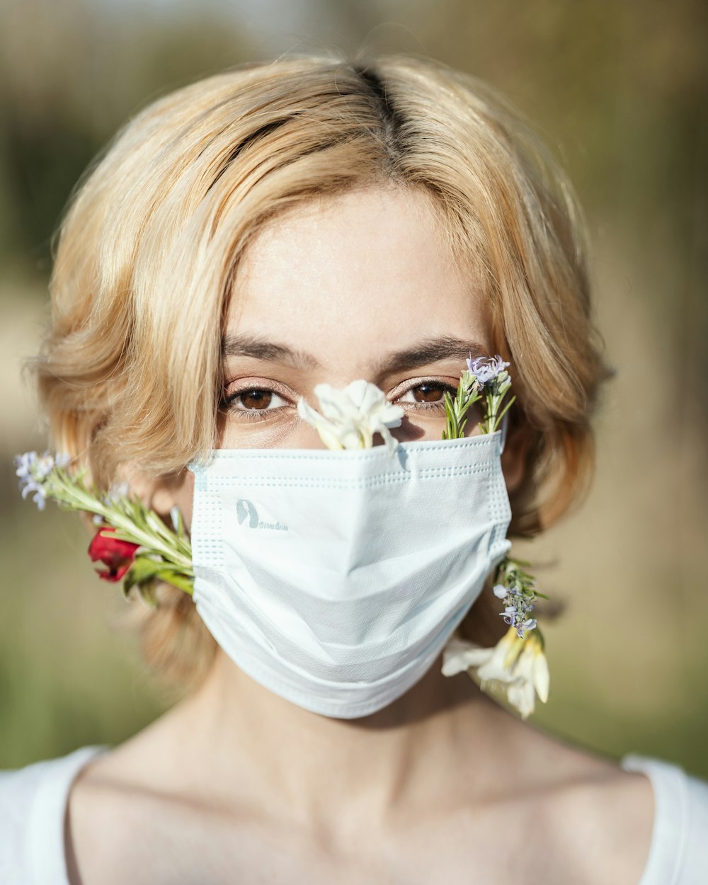 a woman wearing a face mask and flowers in her hair