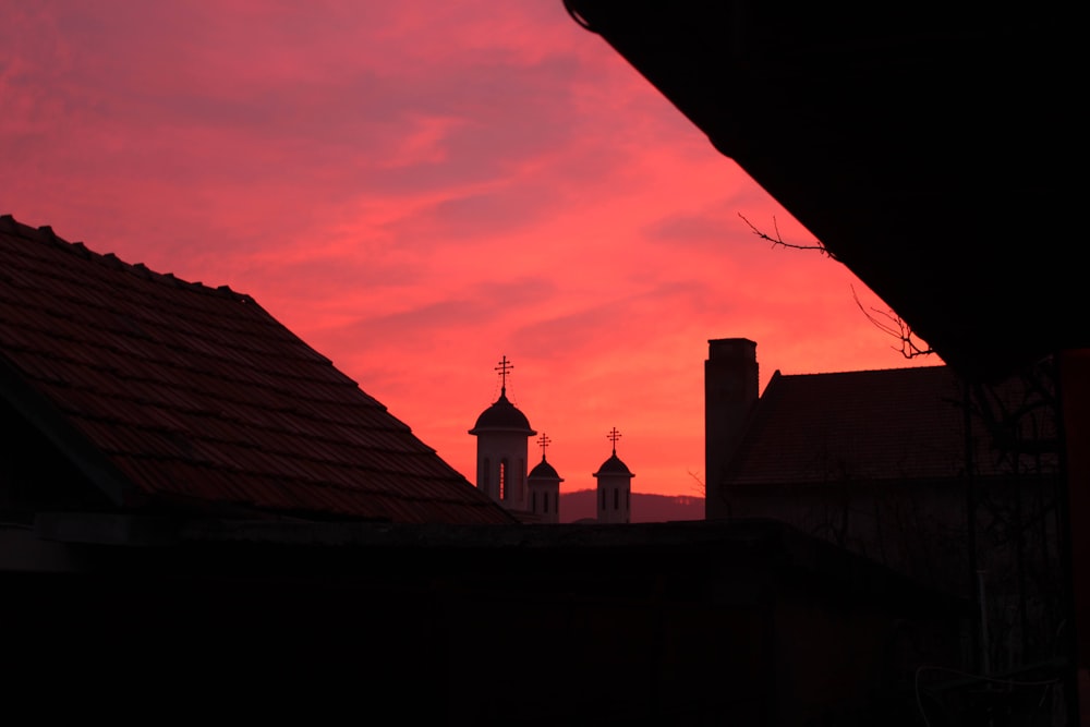 a red sky with a church steeple in the distance