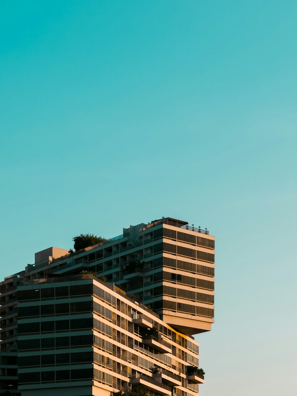 a plane flying over a tall building in the sky