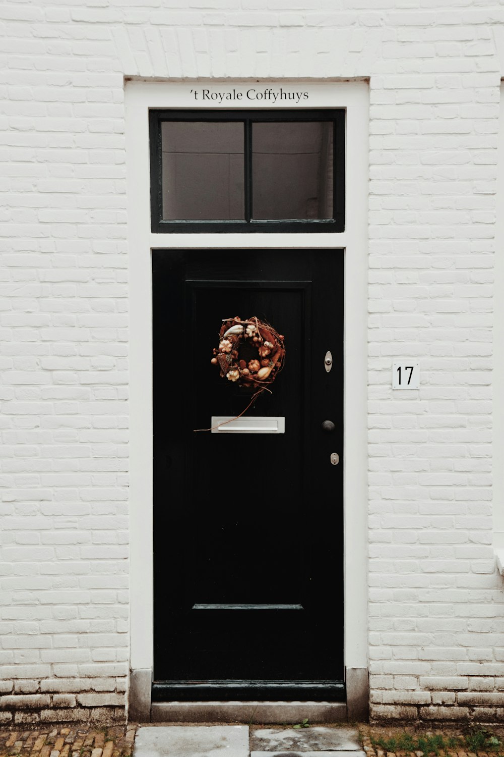 a black door with a wreath on it