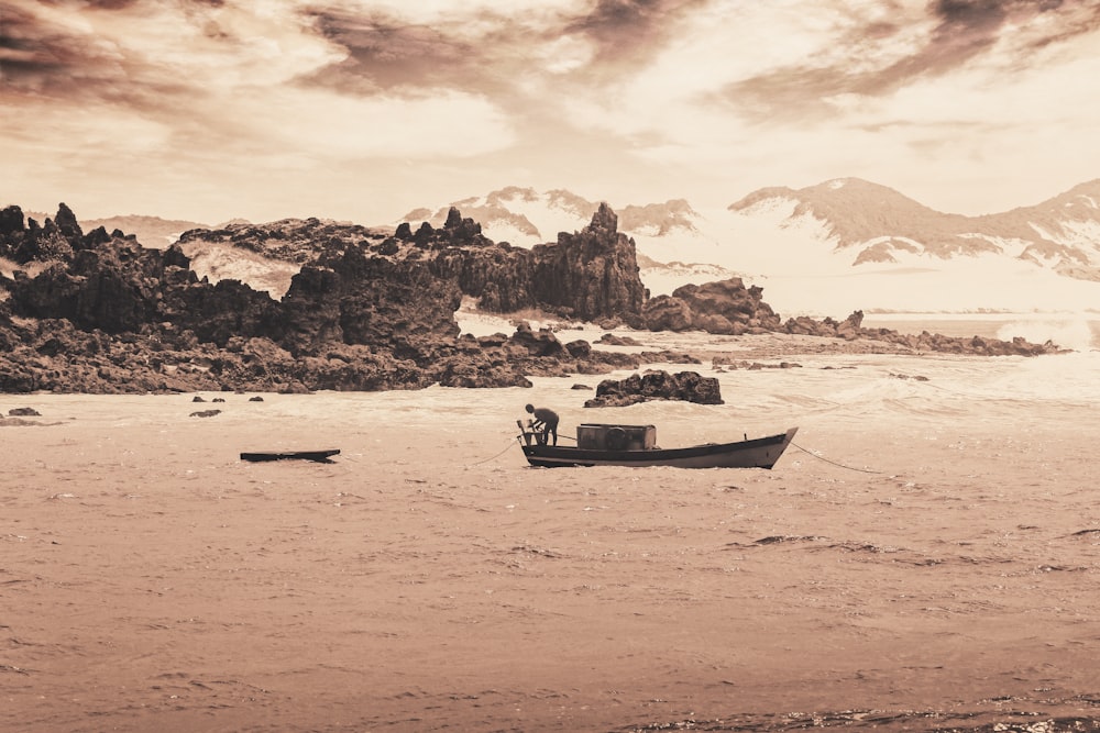 a boat on a beach with mountains in the background