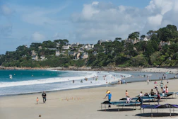 a crowded beach with many people in the water
