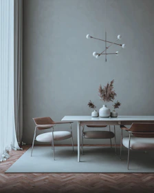 Minimalist dining table set with stone-colored ceramics and delicate glassware under natural light.