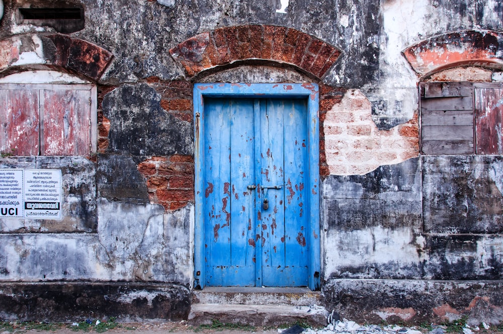 um edifício antigo com uma porta azul e janelas