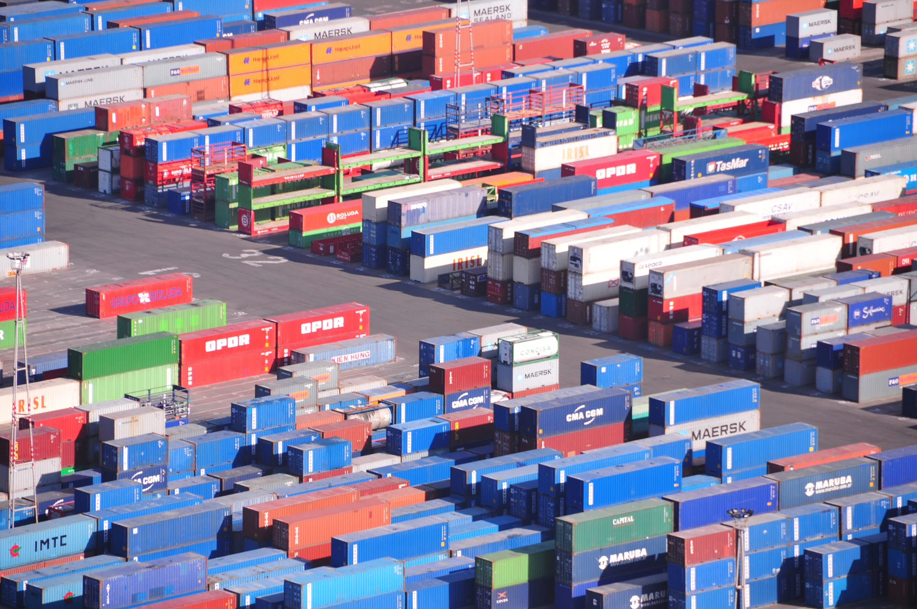 Aerial view of a vast container yard filled with colorful stacked shipping containers at a port gateway