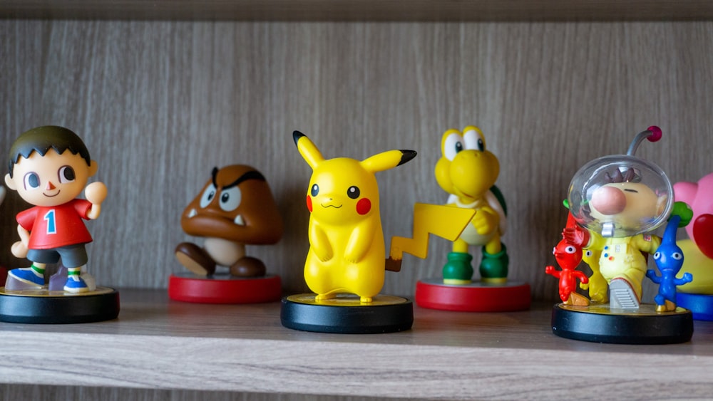 a row of pokemon figurines sitting on top of a shelf