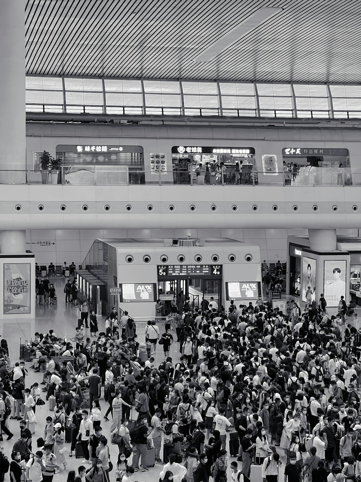 Silhouettes of travelers against a dusk sky, luggage in hand — the human face of youth migration