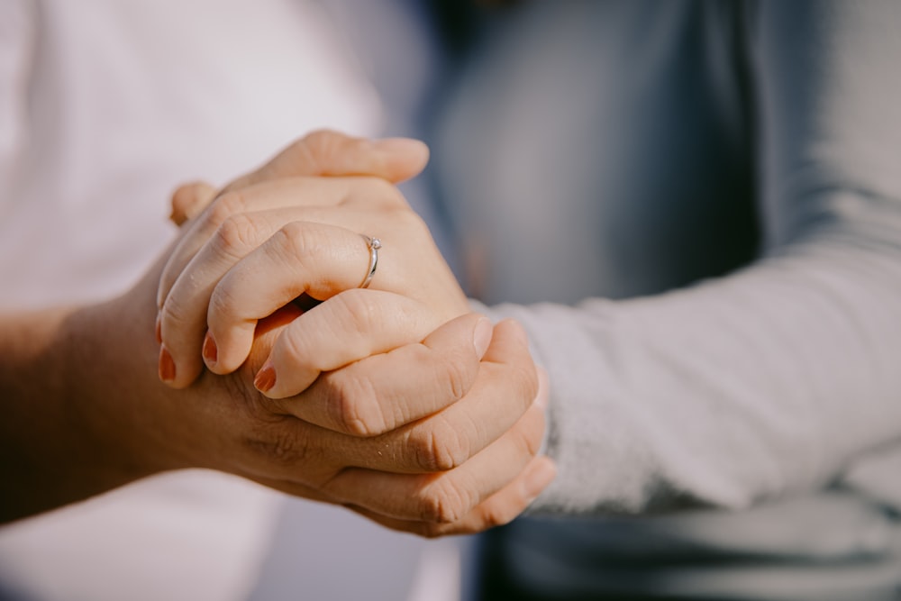 a close up of two people holding hands