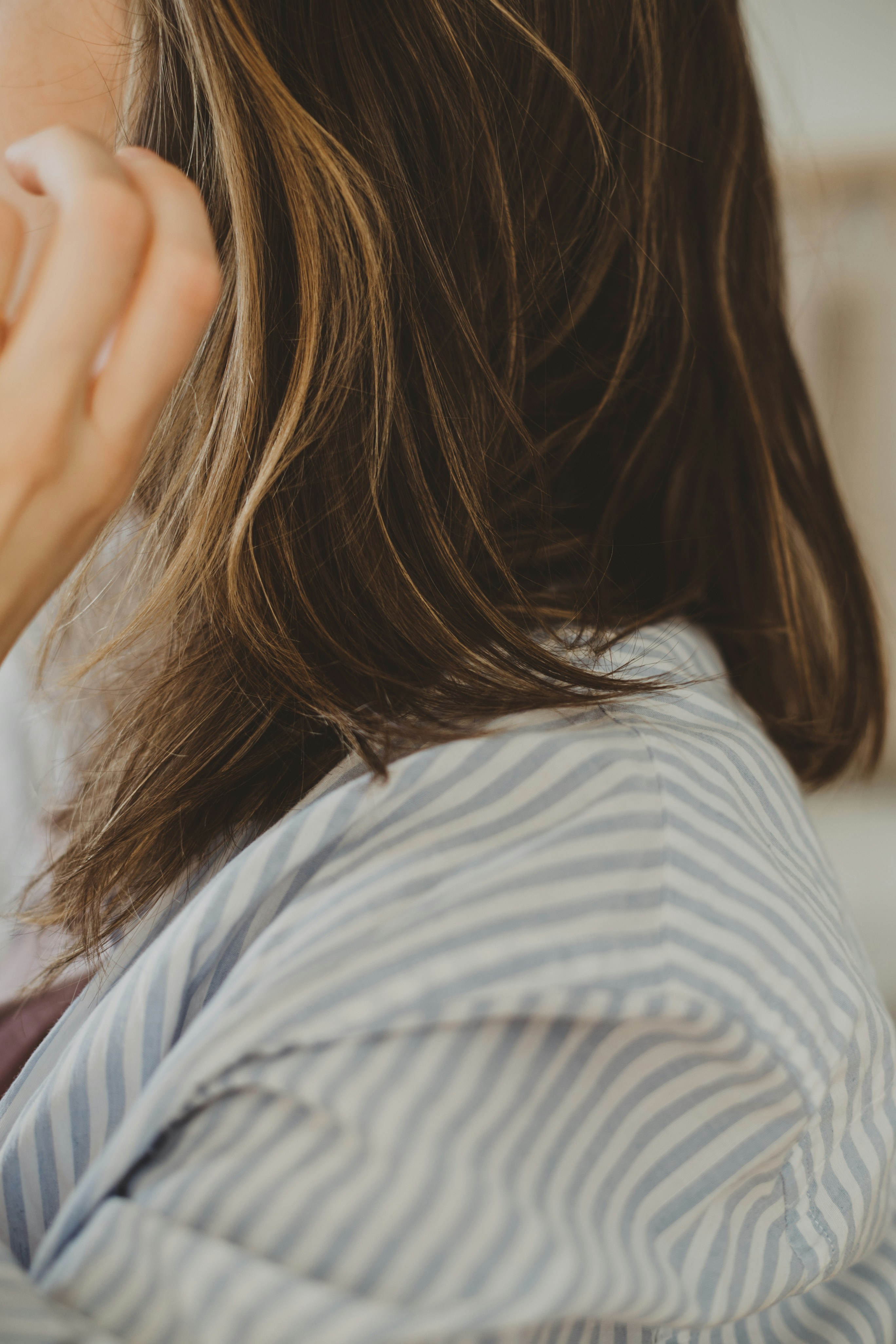 Close-up of natural brunette hair showing seamless blend, ideal for hand-sewn weft extensions.
