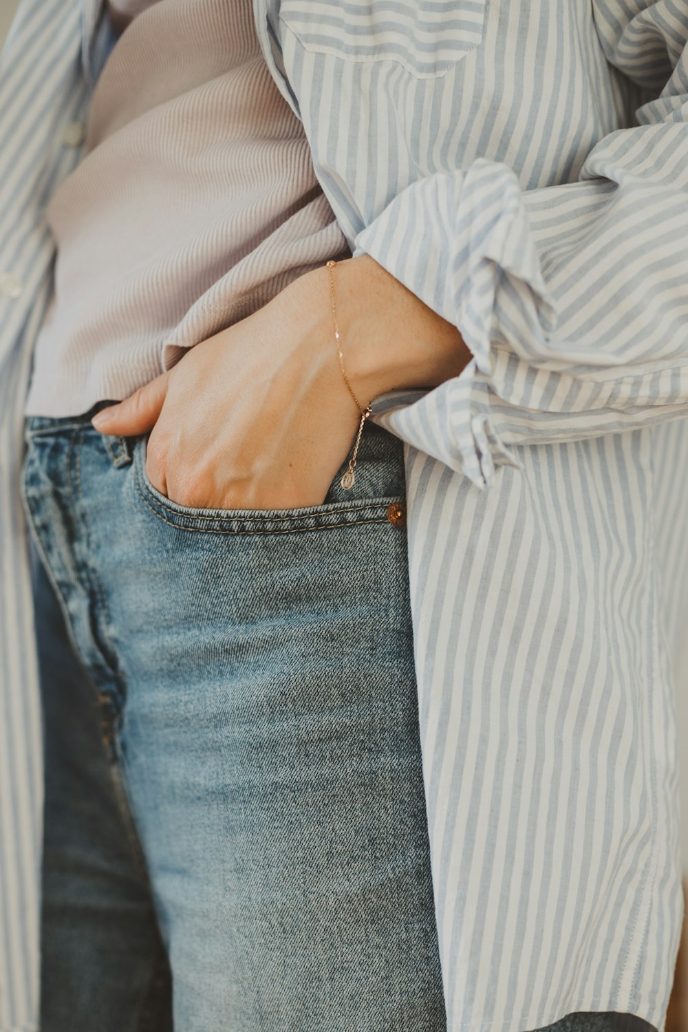 a woman is wearing a striped shirt and jeans