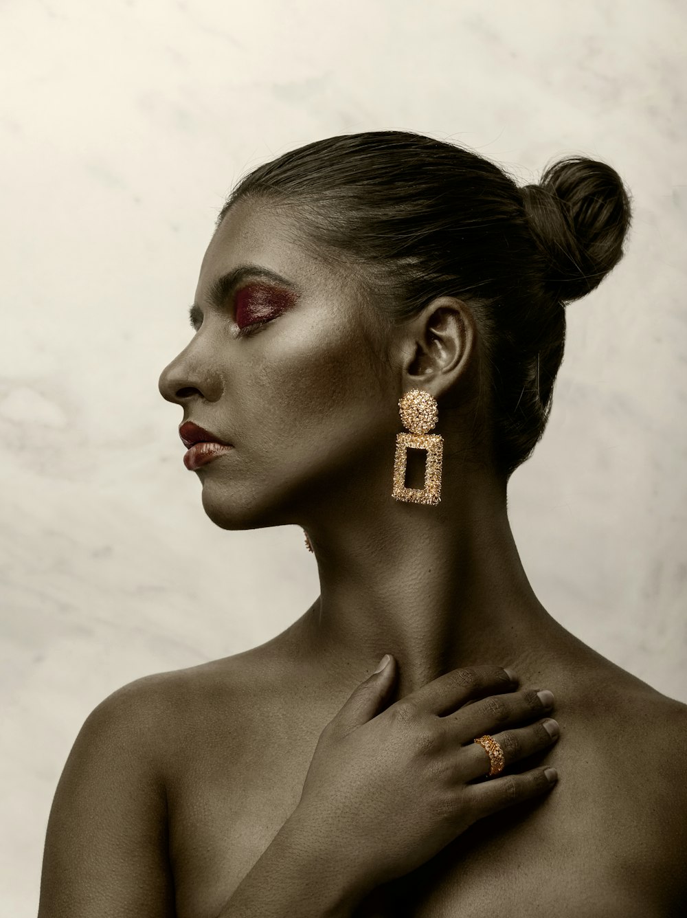 a woman with red makeup and a pair of earrings