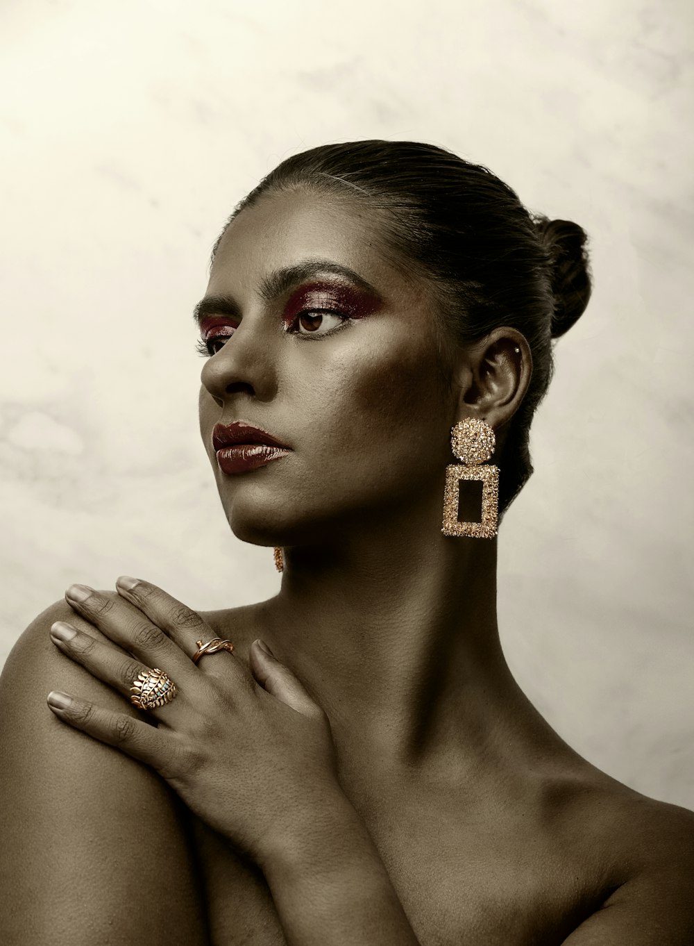 a woman with red makeup and gold jewelry