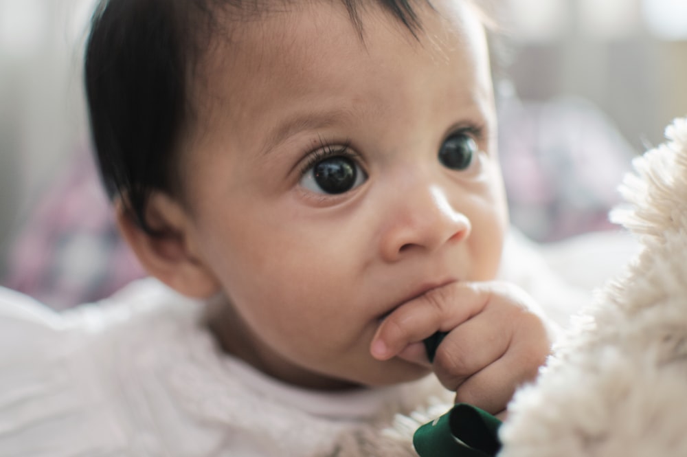 a close up of a baby holding a stuffed animal