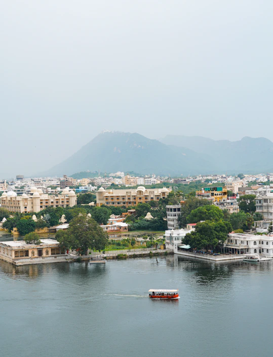 a boat traveling down a river next to a city