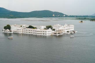 a large white building sitting on top of a lake