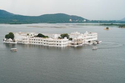 a large white building sitting on top of a lake