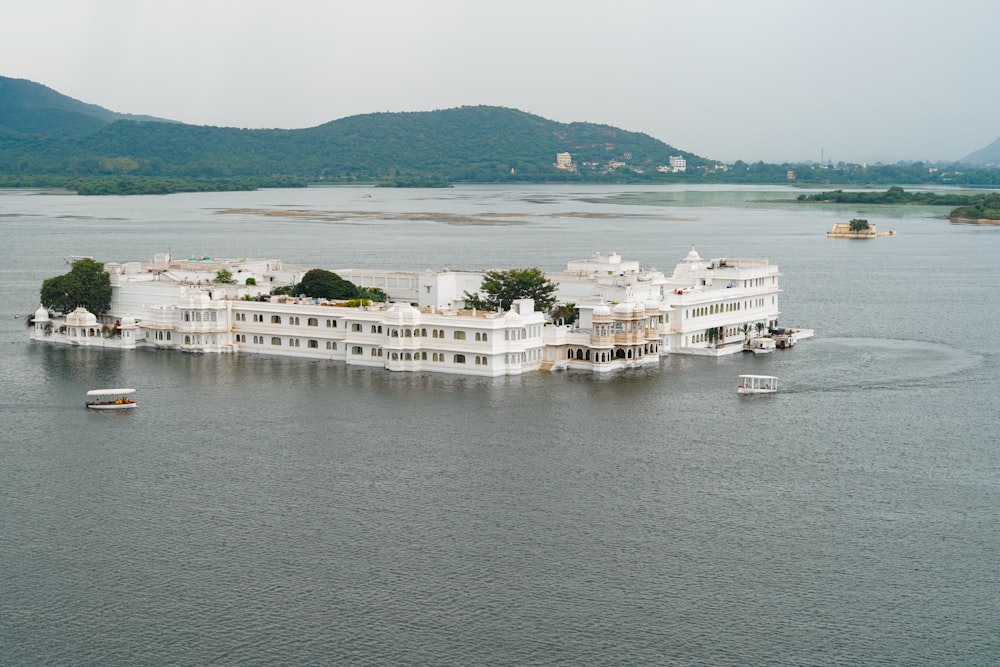 um grande edifício branco sentado no topo de um lago